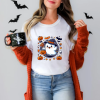 playera color blanco con diseño de fantasma con sombrero de bruja y decoraciones de halloween