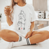 White women's t-shirt with hugging couple and initials.